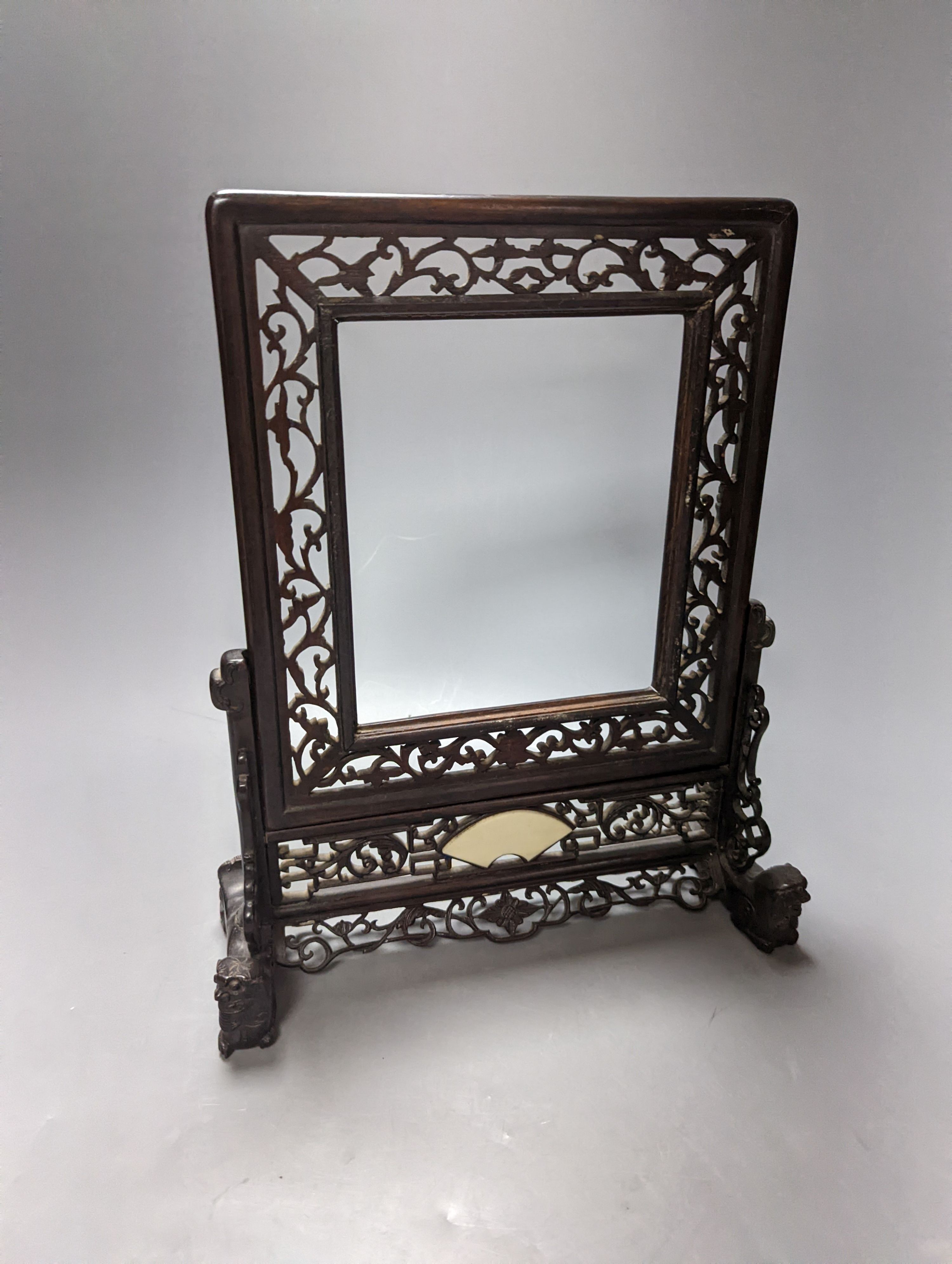 A Chinese hardwood carved table screen, frame and stand, 30 cms high.